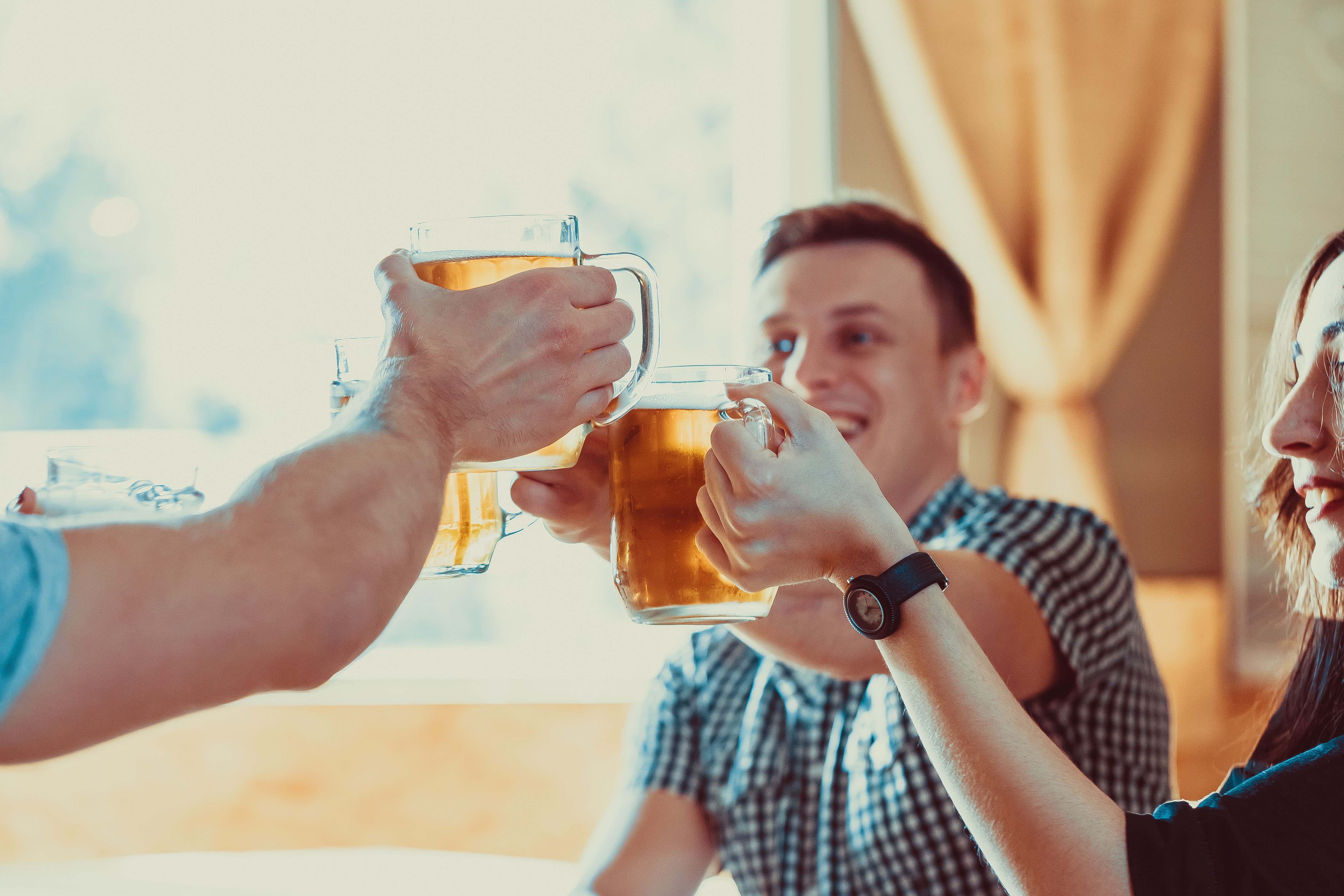 Zwei Personen stoßen mit Bier an